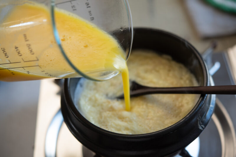 Pour egg mixture to the boiling chicken stock in a pot.