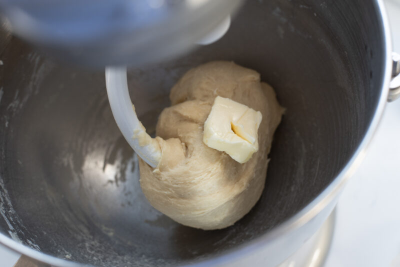 A slice of softened butter is added to the brioche dough.