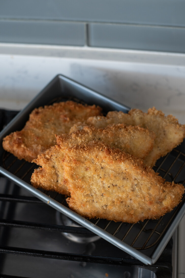 Freshly fried breaded cutlets resting on rack to stay crunchy