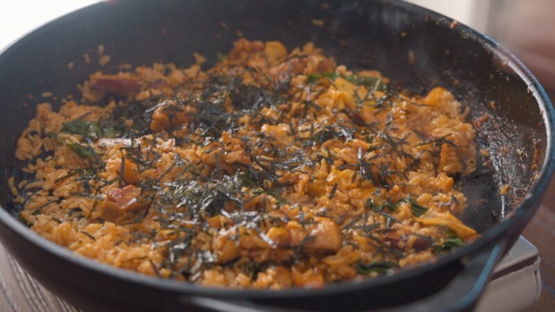 Crumbled seaweed sprinkled on top of dakgalbi fried rice.