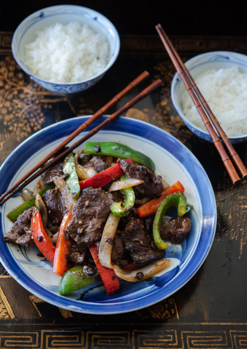 beef and colorful pepper stir fry served hot with rice.