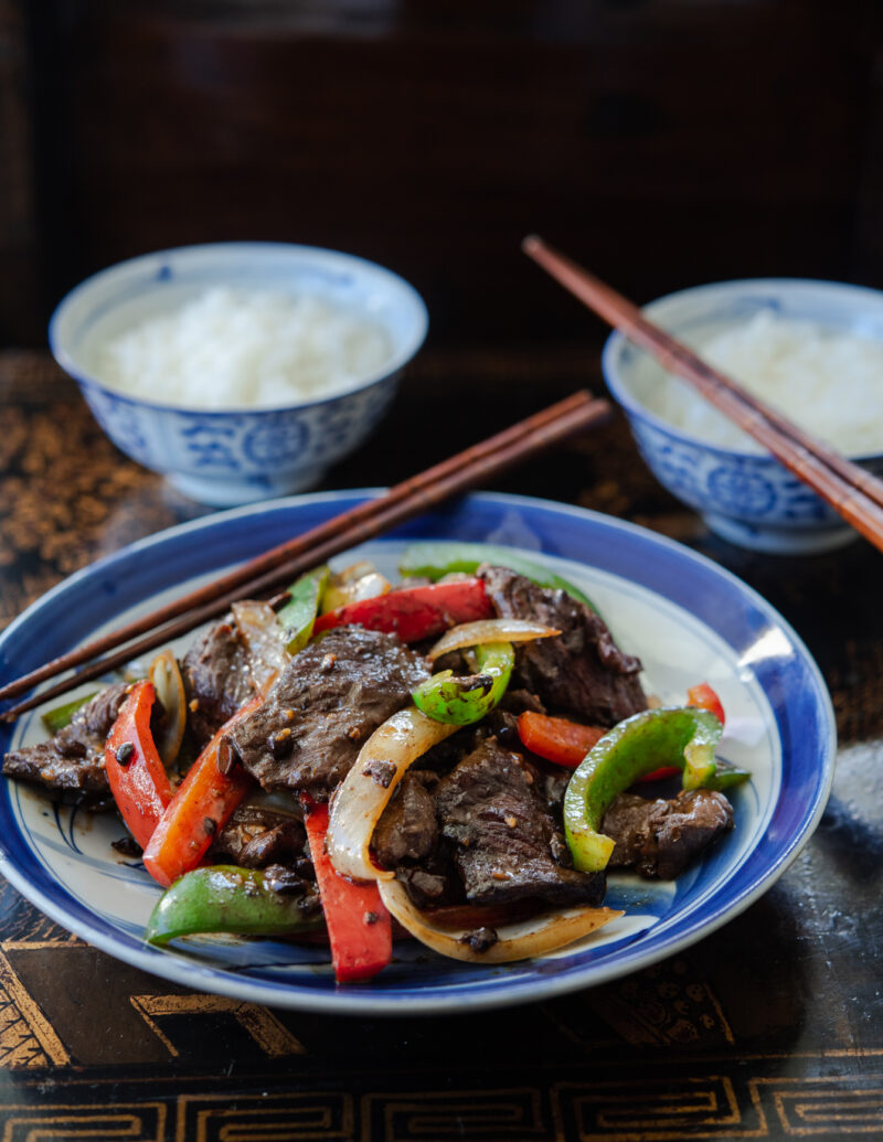 A plate of Chinese beef and pepper stir-fry served with rice.