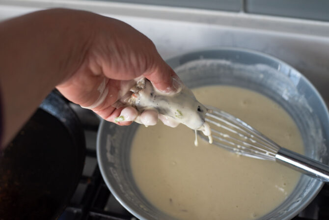 Coat Gimmari with the light Korean frying mix batter shaking off the excess.