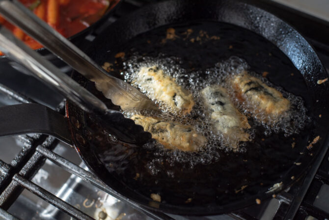 Gimmari is deep-fried in hot oil until golden brown and crisp.