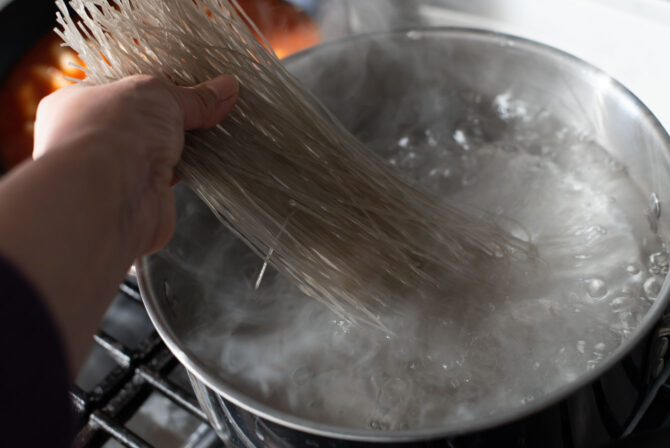 Korean glass noodles are added into the boiling water.