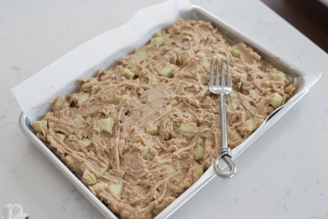 Apple brownies batter is spread on a baking pan