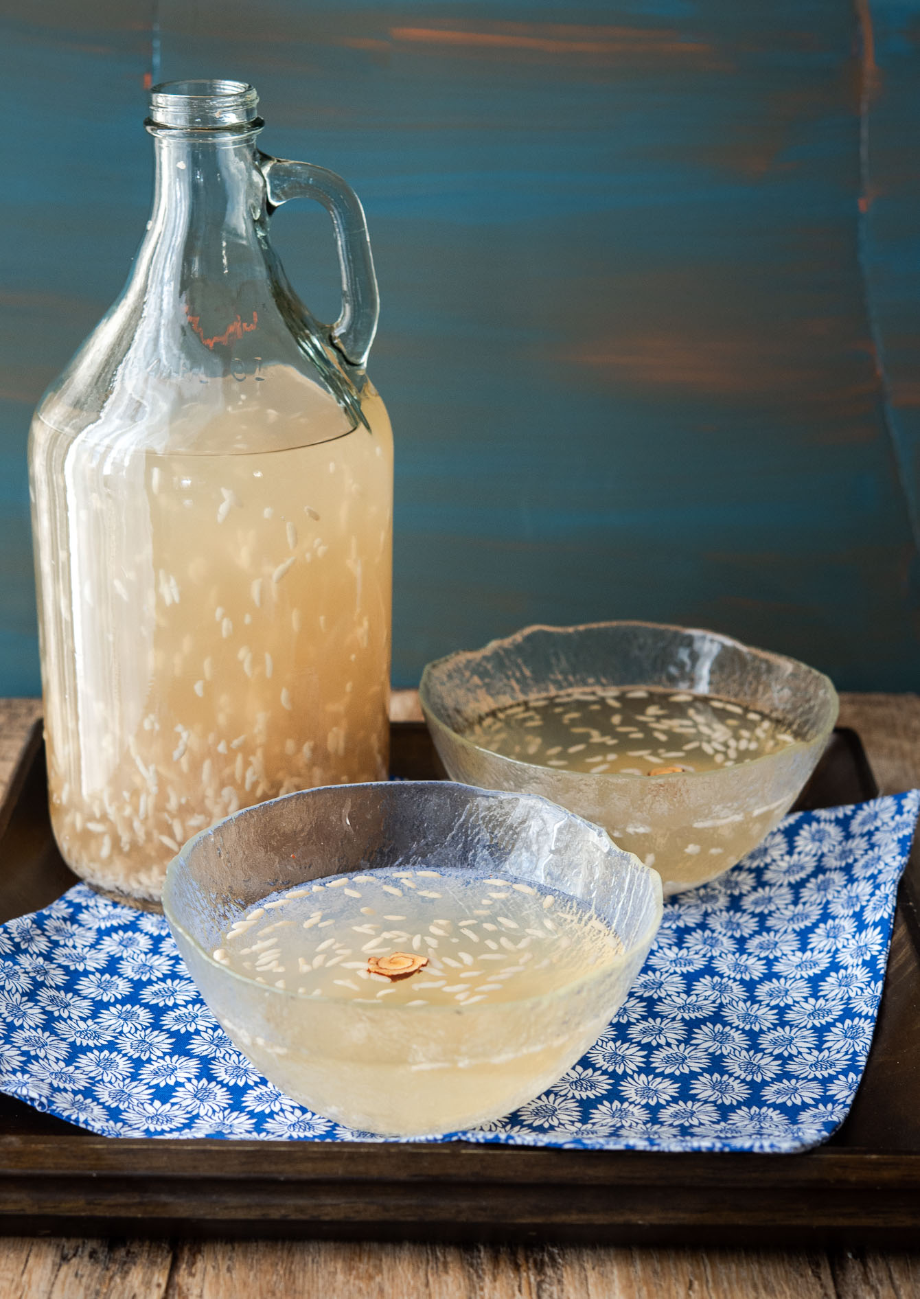 Two glass bowls of sikhye garnished with rice grains on top.