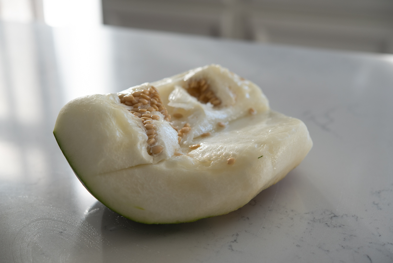 Winter melon chunk with seeds on a cutting board
