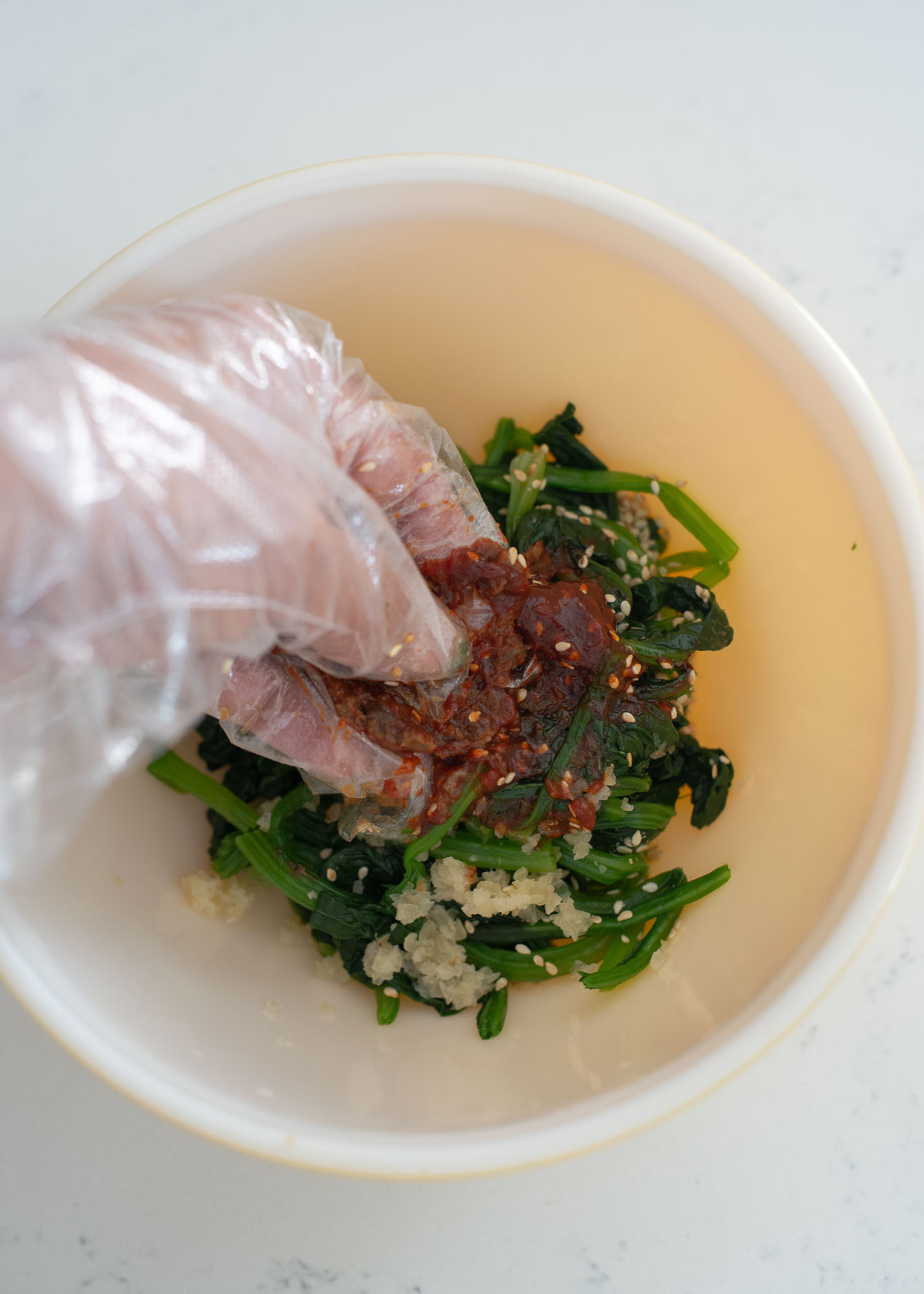 Korean pastes are rubbed with finger to mix for making Korean spinach