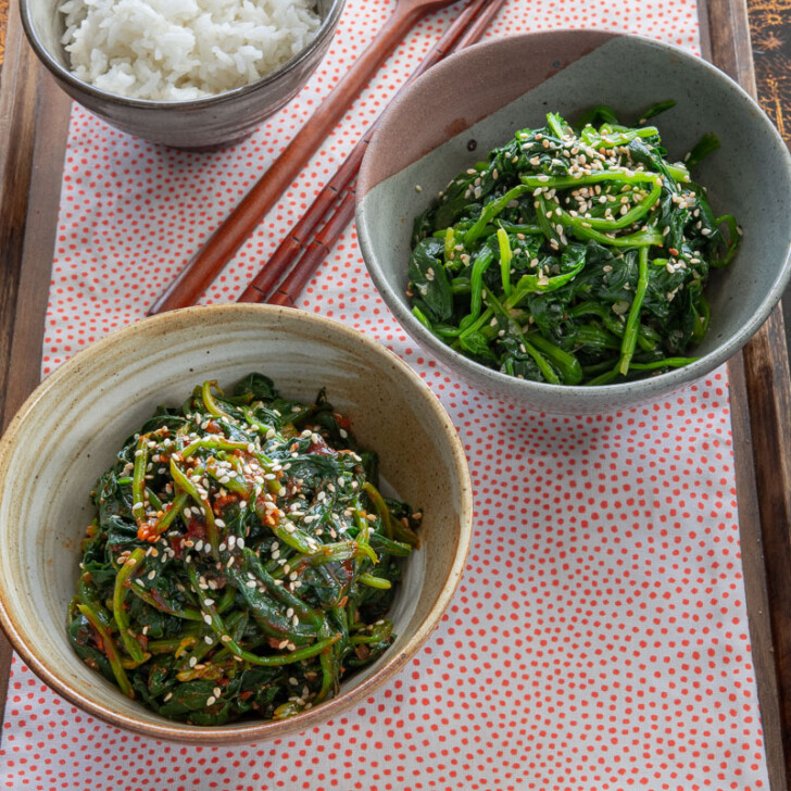 Two Korean spinach side dishes are served with rice on a tray.