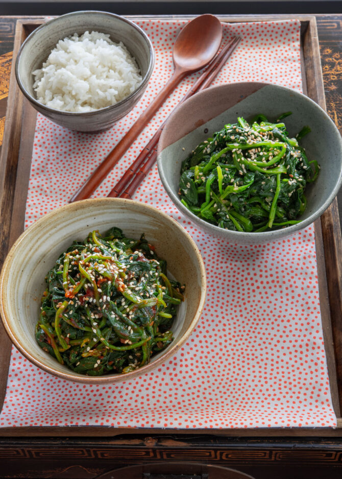 Two Korean spinach side dishes are served with rice on a tray.