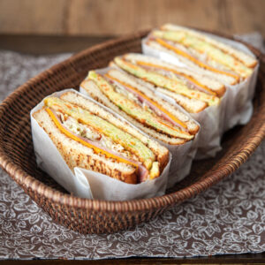 Korean street toast sandwich is wrapped and placed in a basket