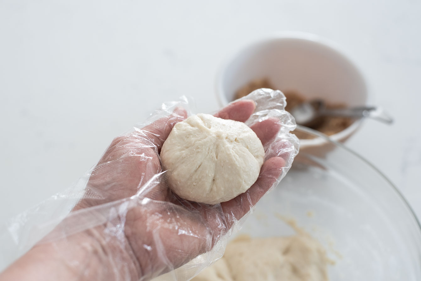 Pinching the hotteok dough together to seal.