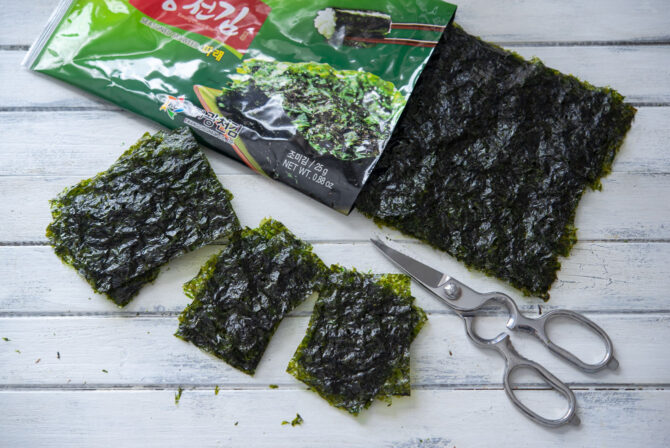 Sheets of roasted Korean seaweed is cut into small sizes