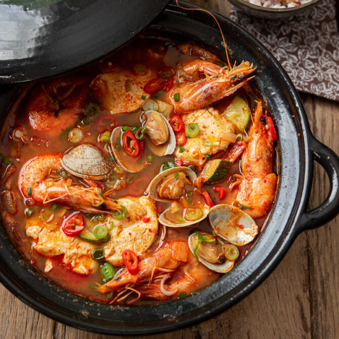 Korean soondubu jjigae with clam and shrimp is served with rice