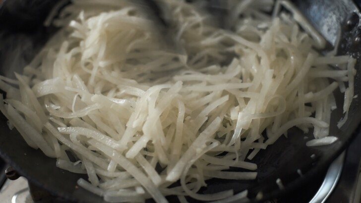 Sautéed, soft Korean radish in skillet.