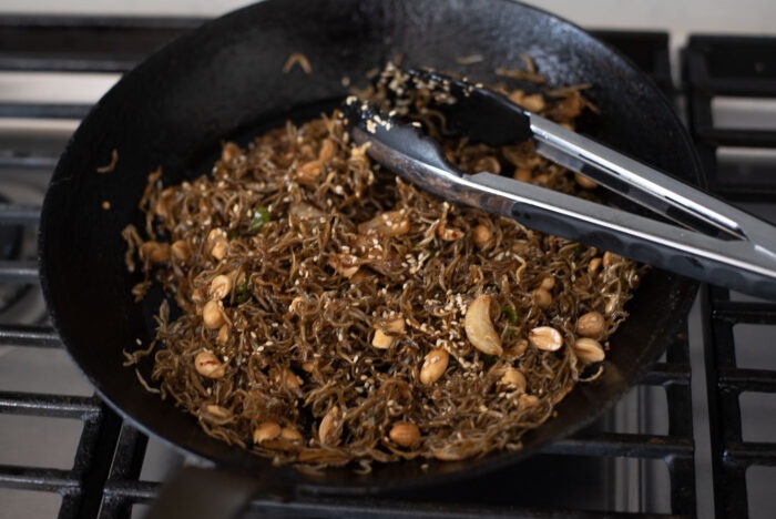 Tiny anchovies and peanuts are mixed with the savory sauce in a skillet