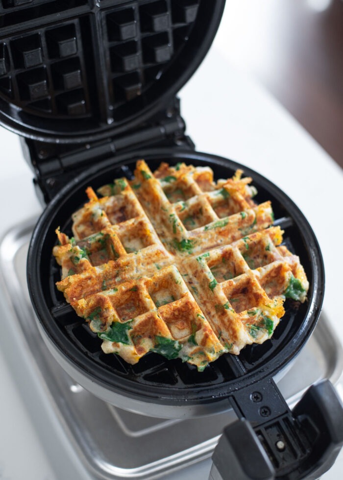 Golden crisp savory waffles are finished cooking in a waffle maker