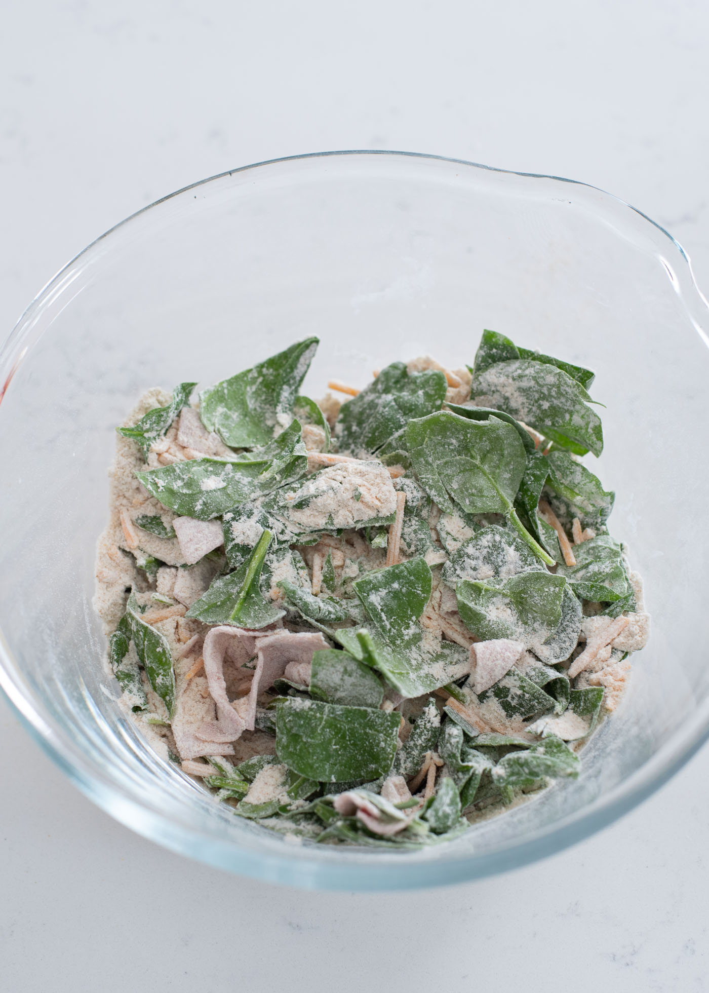 Dried flours and seasoning are added to the spinach, ham and cheese mixture.