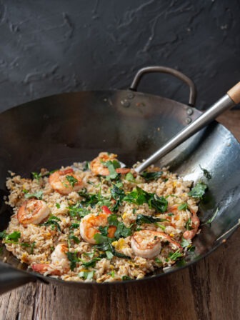 Thai basil and shrimp fried rice is cooked in a wok