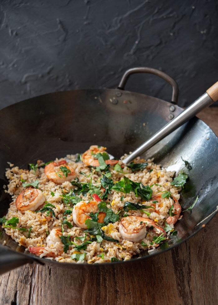 Thai basil and shrimp fried rice  is cooked in a wok