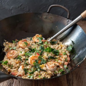 Thai basil and shrimp fried rice is cooked in a wok