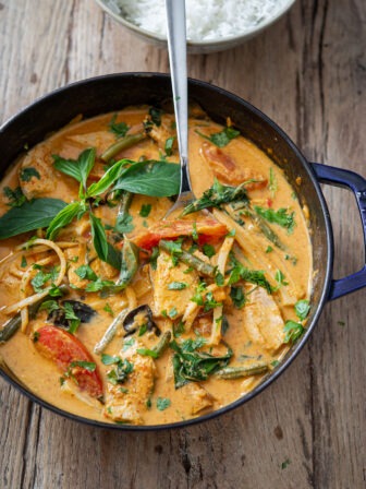 Thai red curry is made with chicken and vegetables in a pot