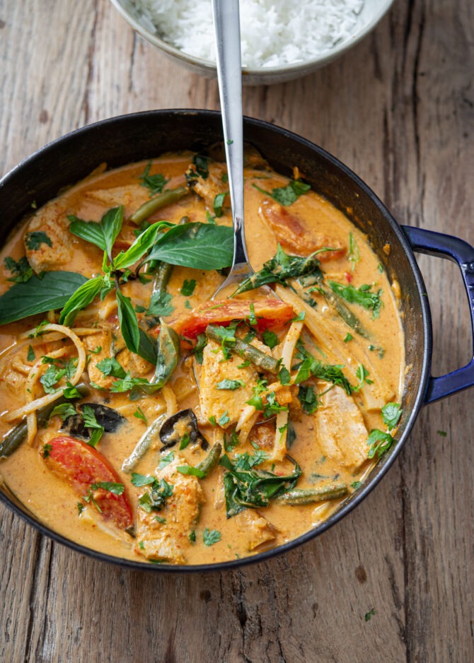 Thai red curry is made with chicken and vegetables in a pot