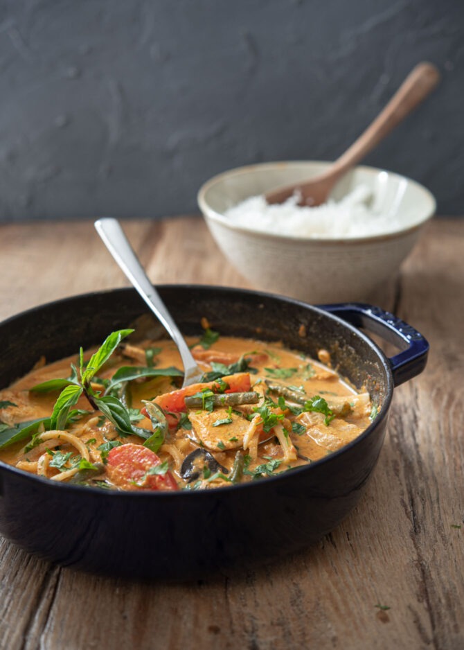 A pot of Thai red curry with chicken is served with rice