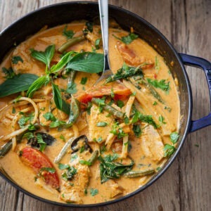 Thai red curry is made with chicken and vegetables in a pot