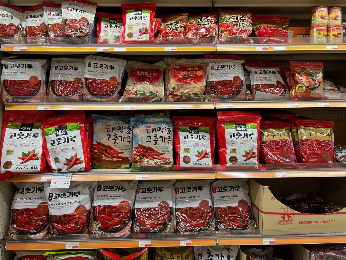 A variety of Korean chili flakes are displayed on the shelf