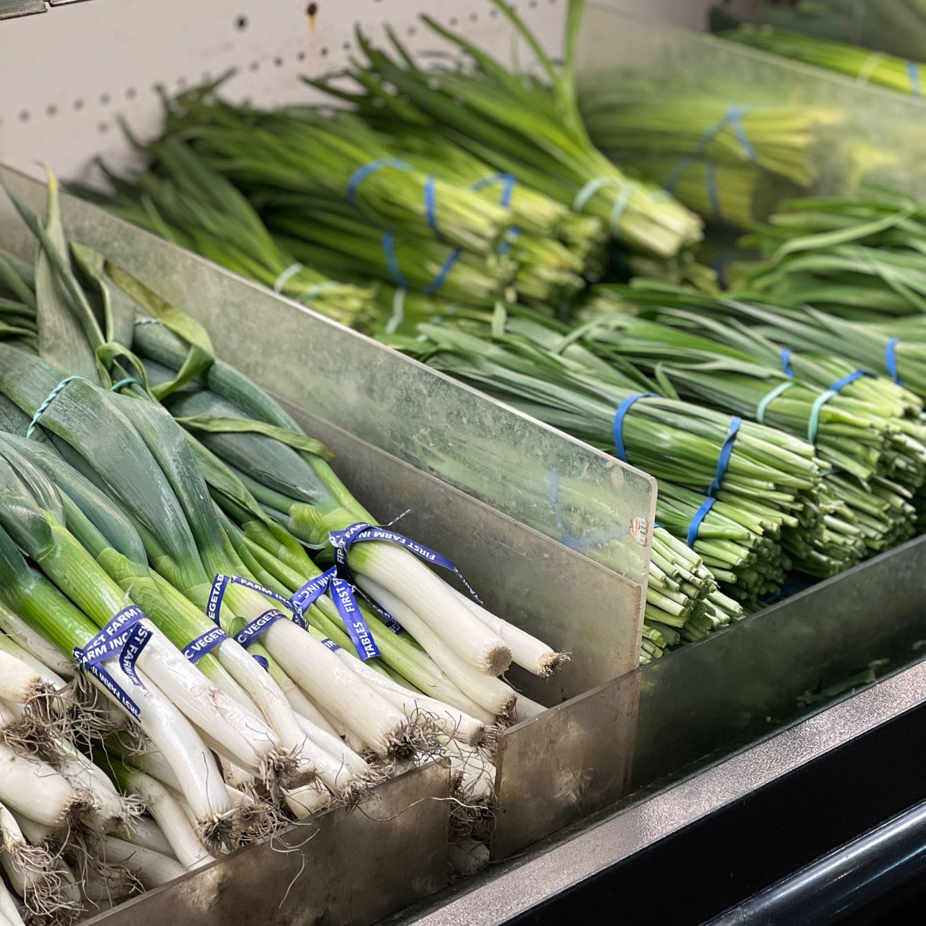 Bunches of Asian leeks and chives are displayed.