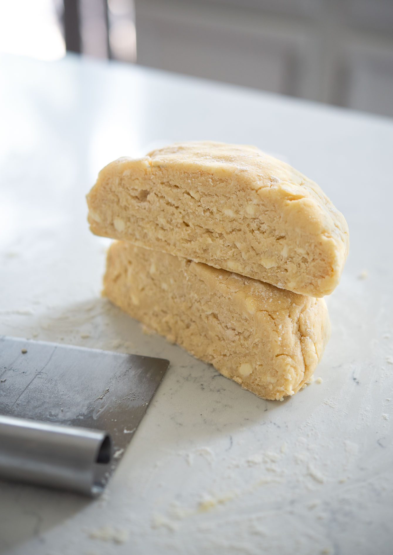 Pie dough made with lard and butter is showing small pieces of fat in the dough