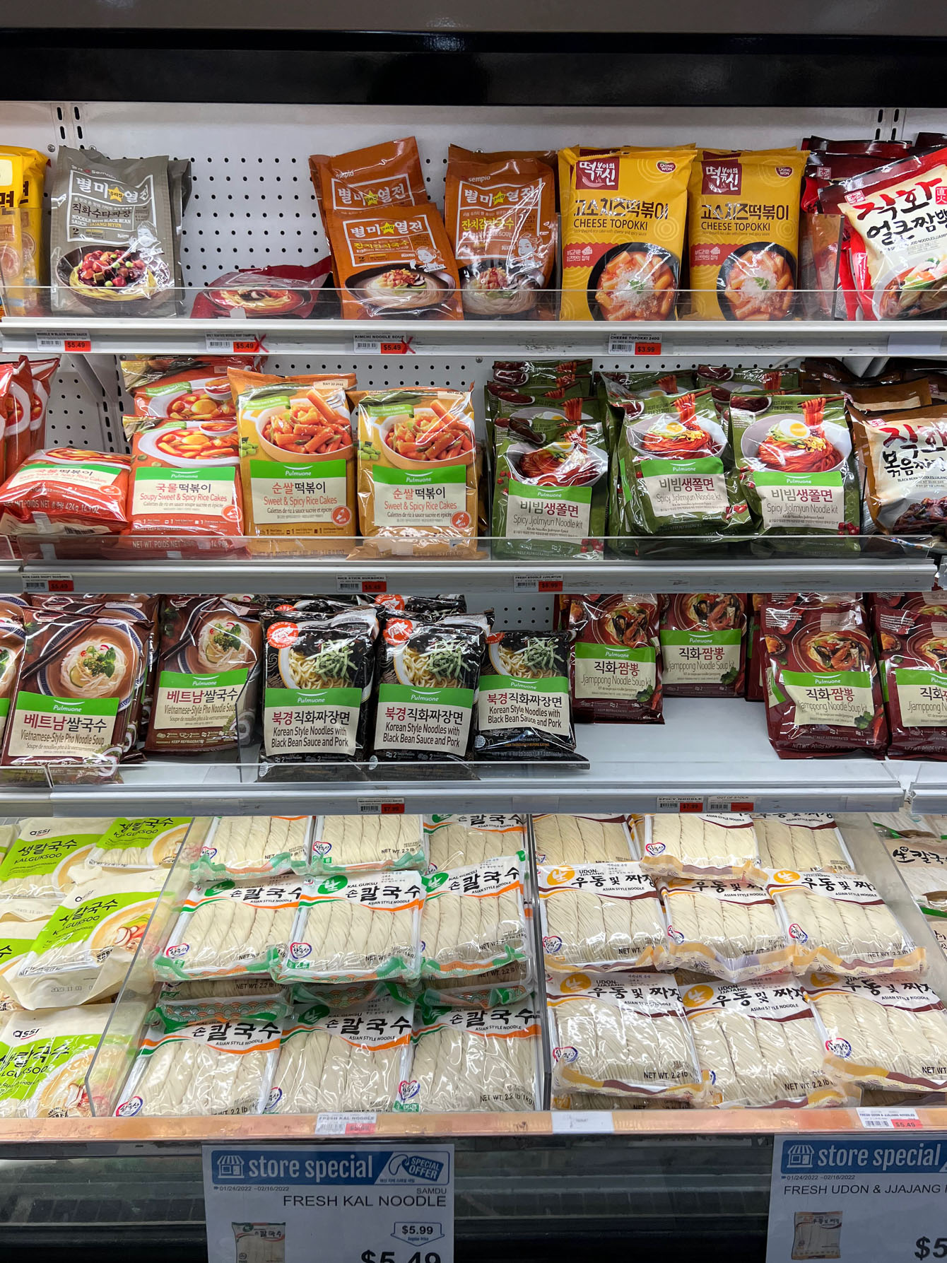 Various Korean wheat noodles displayed in the refrigerator section of Korean grocery store.