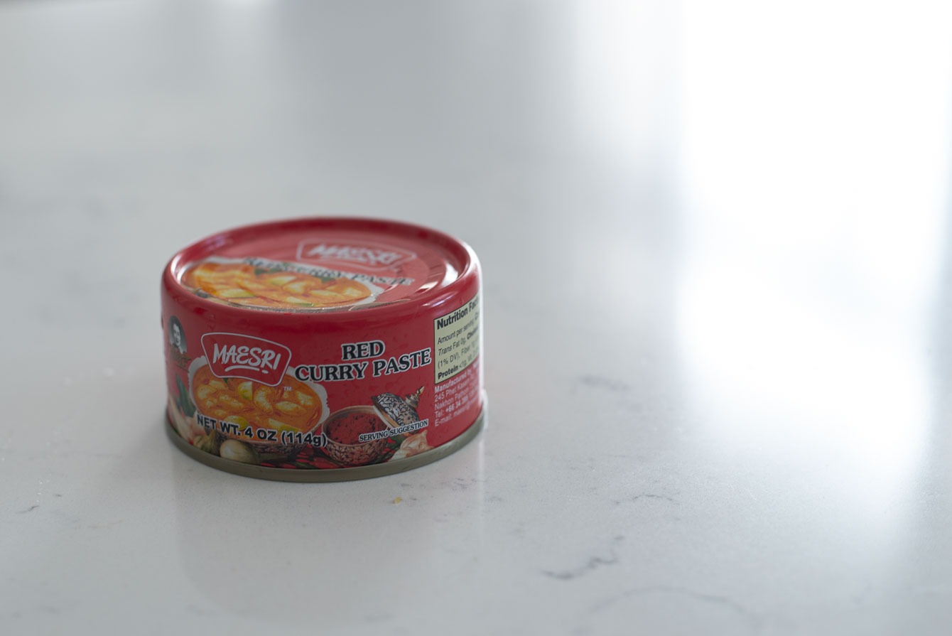A can of store bought Thai red curry paste is presented