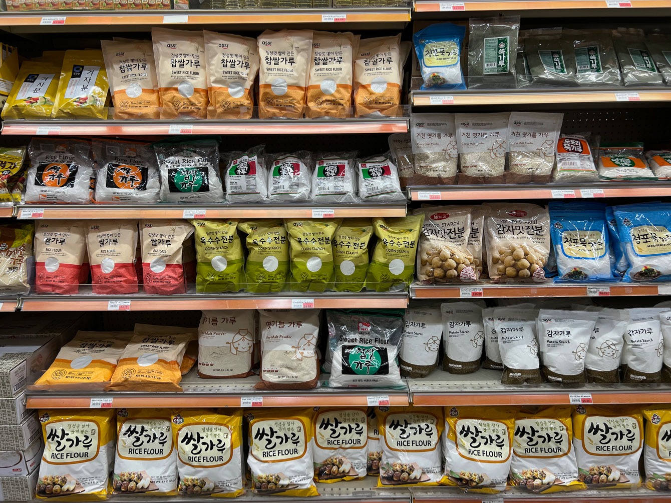 Various type of Korean rice flour, corn flour, and potato flour are displayed on the shelf