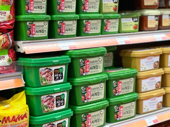 Green containers of Korean ssamjang is displayed on a shelf