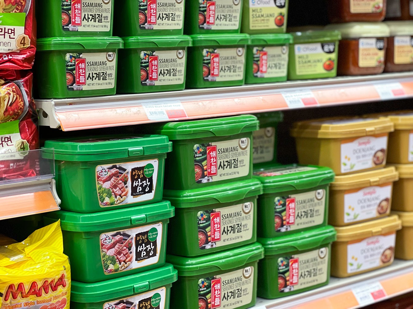 Green container of Korean ssamjang shown as Korean food staples.