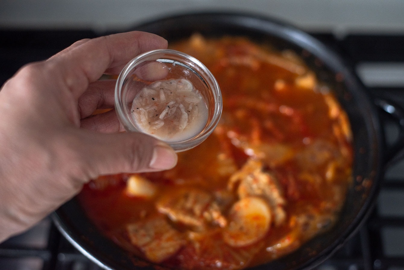 Salted shrimp added into a pot of authentic kimchi jjigae (kimchi stew).