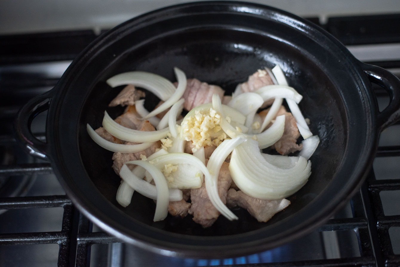 Sliced onion and minced garlic are added to make a classic kimchi jjigae (stew).