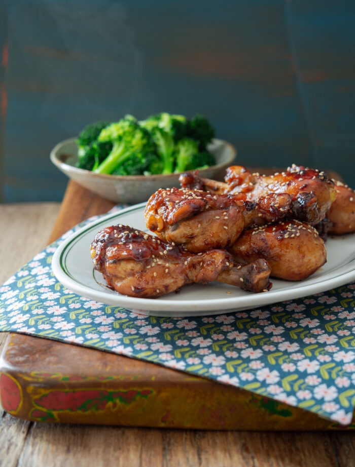teriyaki chicken drumsticks are served with steamed broccoli