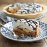 A slice of banoffee pie is served on a blue plate with a fork.