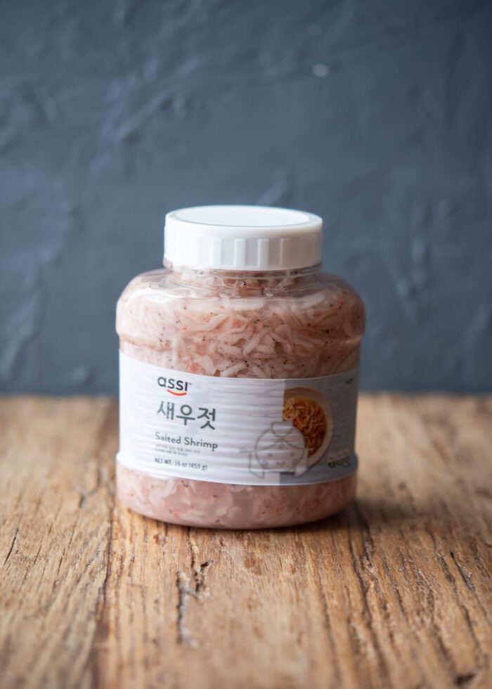 A jar of Korean salted shrimp is placed on a counter