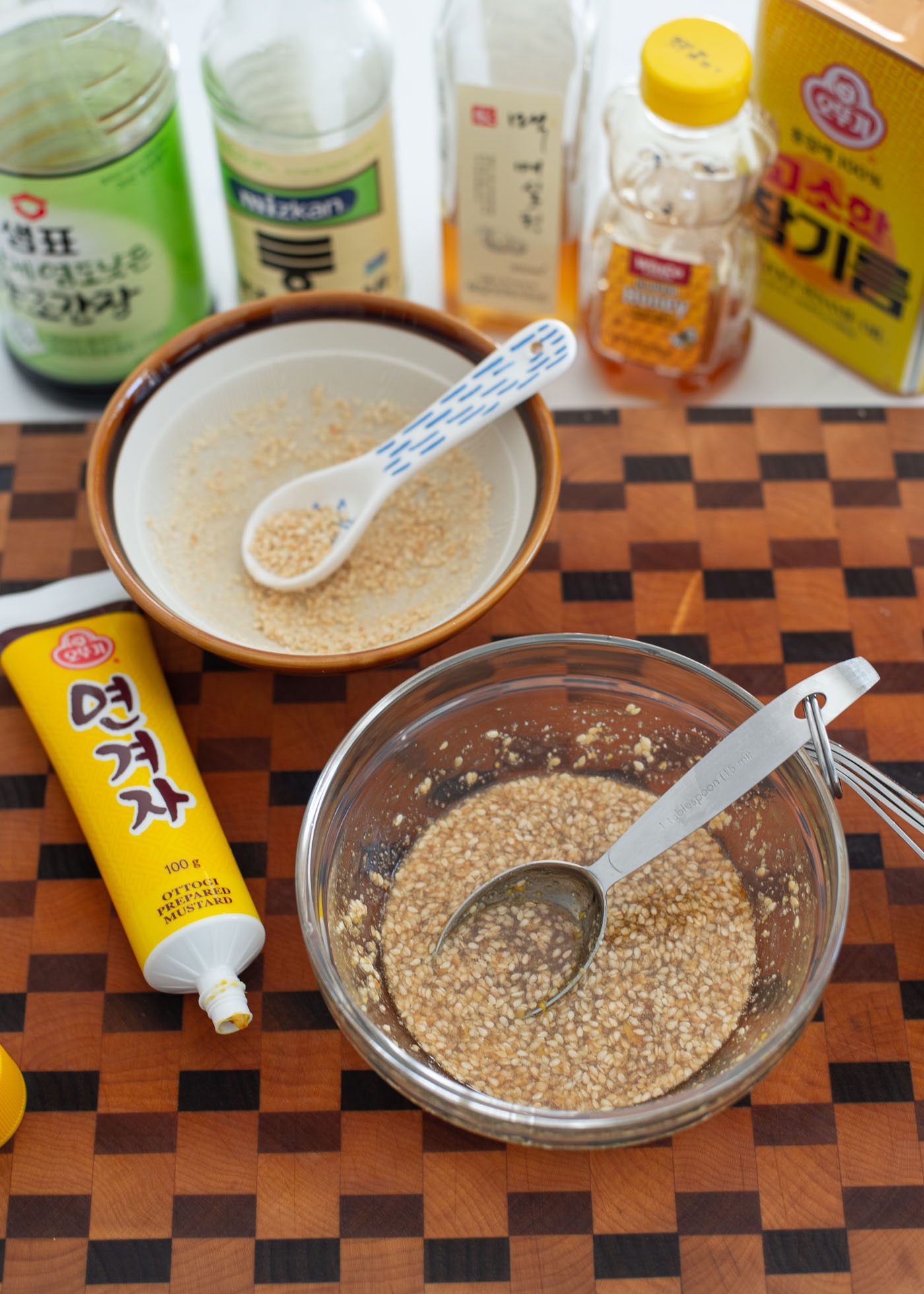 Salad dressing with coarsely ground sesame seeds and Korean mustard are combined in a small bowl