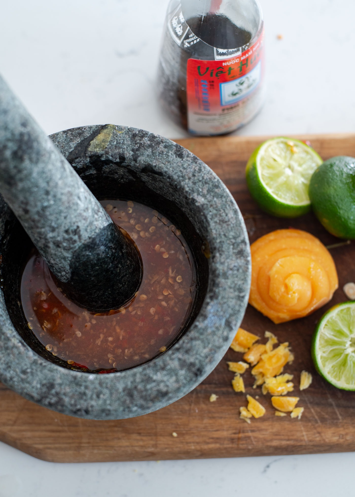 Thai fish sauce dressing is made in a mortar with palm sugar and lime.