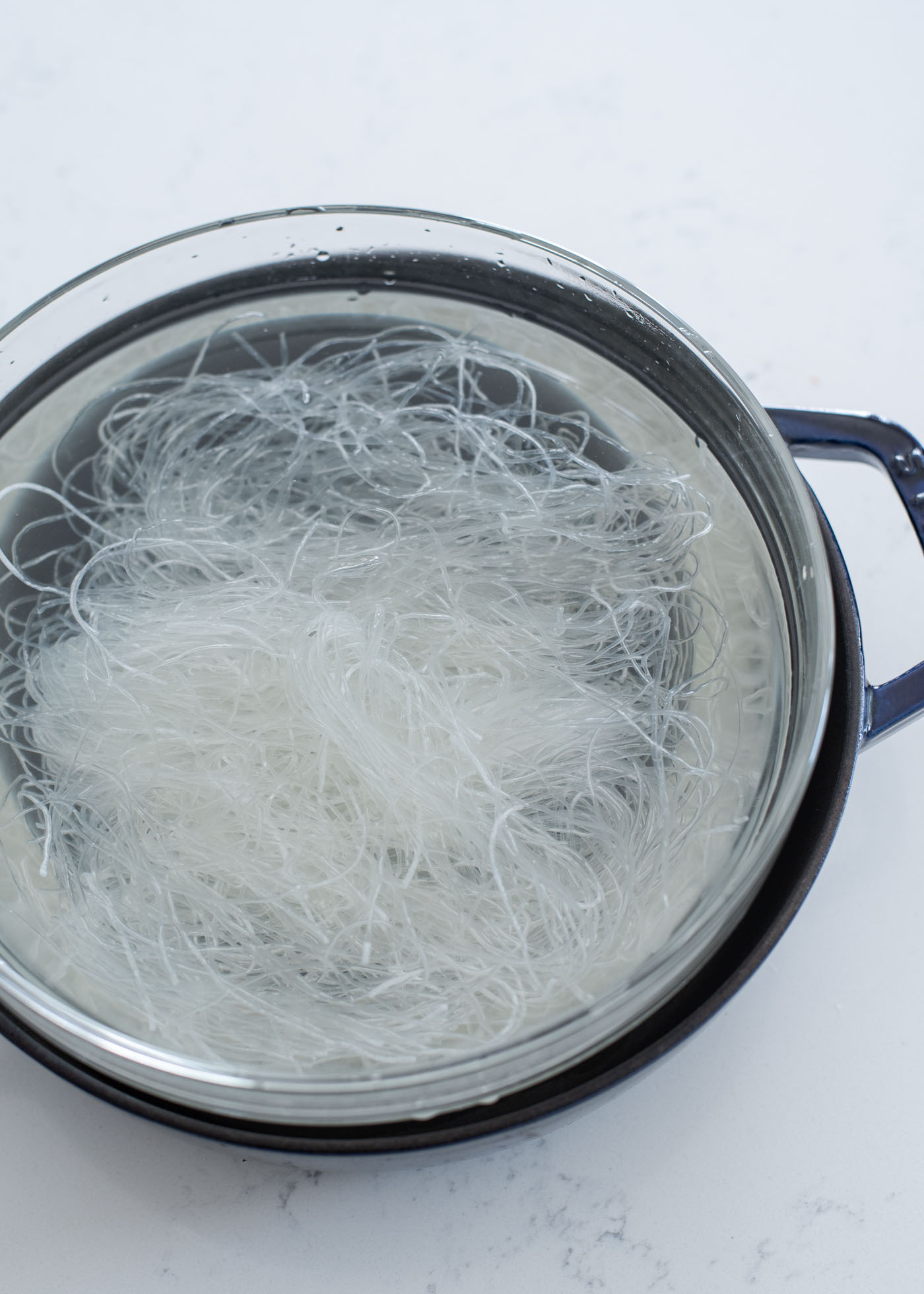 Glass noodles are soaking in the water in bowl.