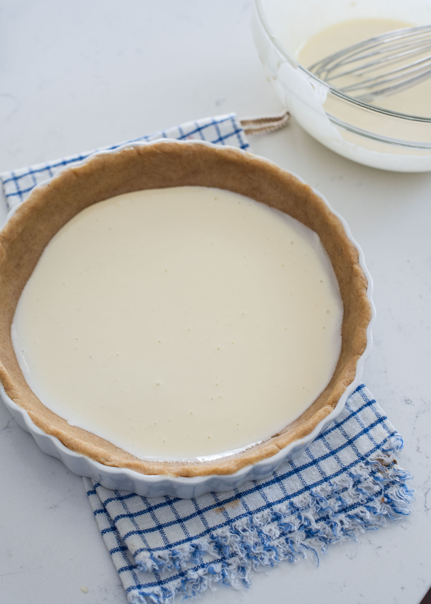 Half of cream filling is poured on a prepared pie crust in a pan.