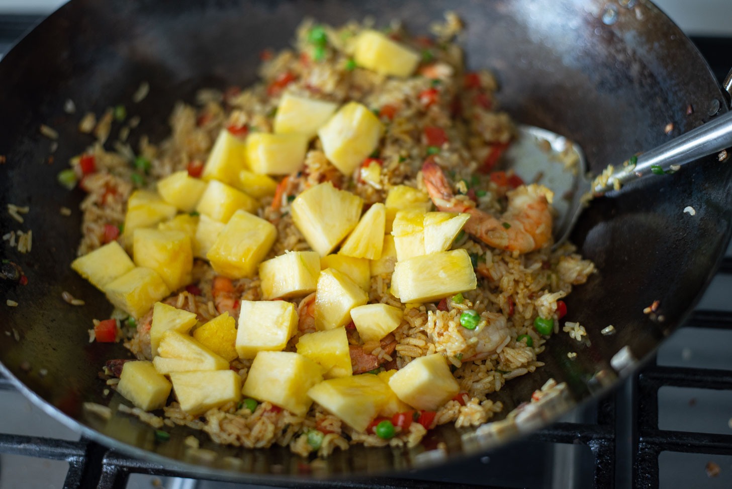 Pineapple chunks are added to the fried rice mixture to finish off.