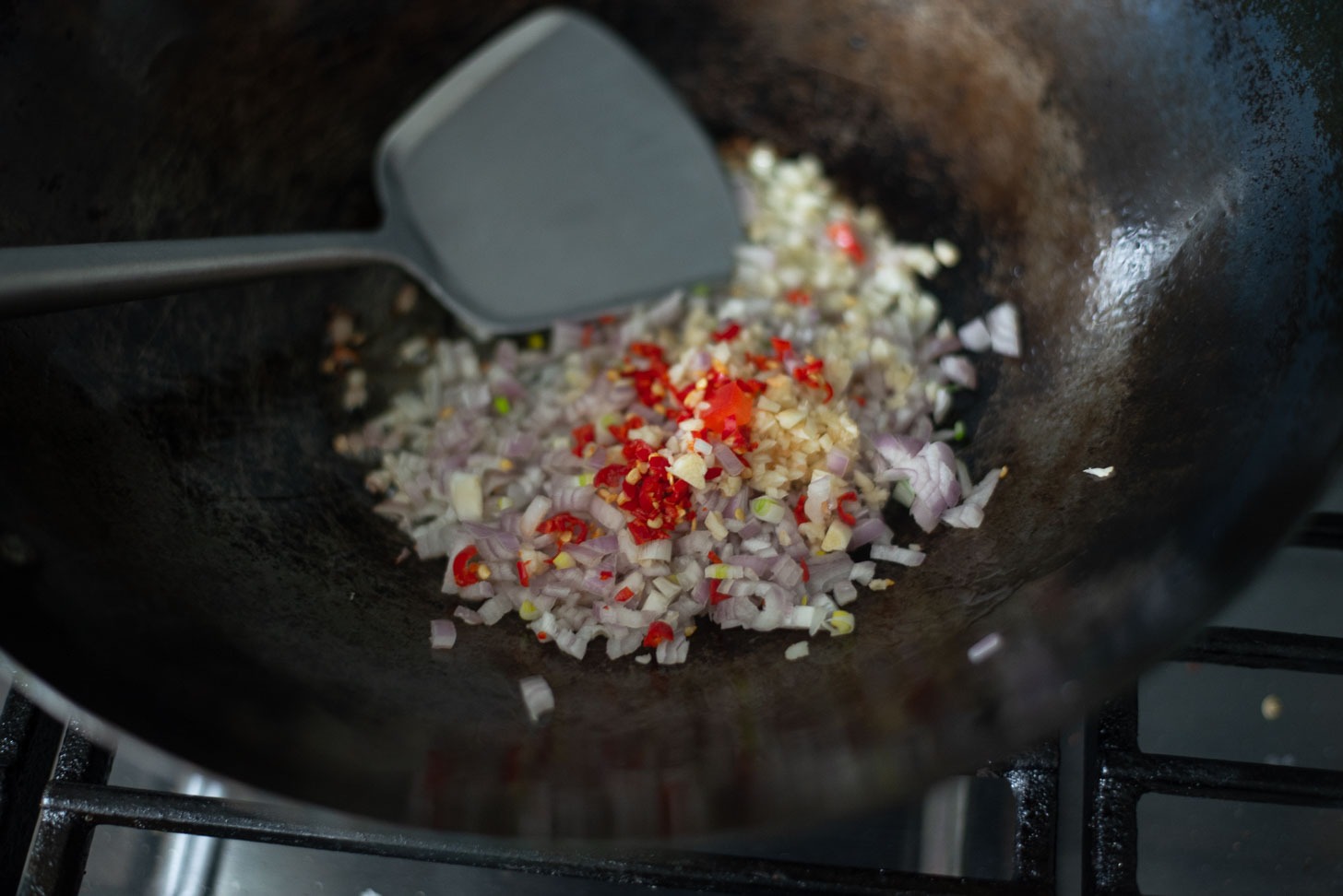 Aromatic vegetables are stir frying in a wok for Thai style fried rice.