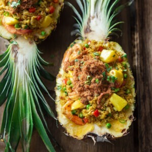 Pineapple fried rice is served in two pineapple boats topped with pork floss.